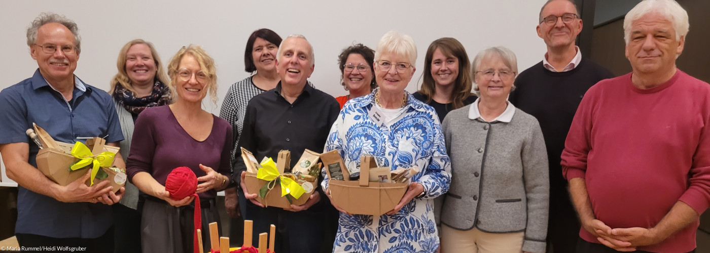 elf Personen, teils mit Geschenkkörben in der Hand