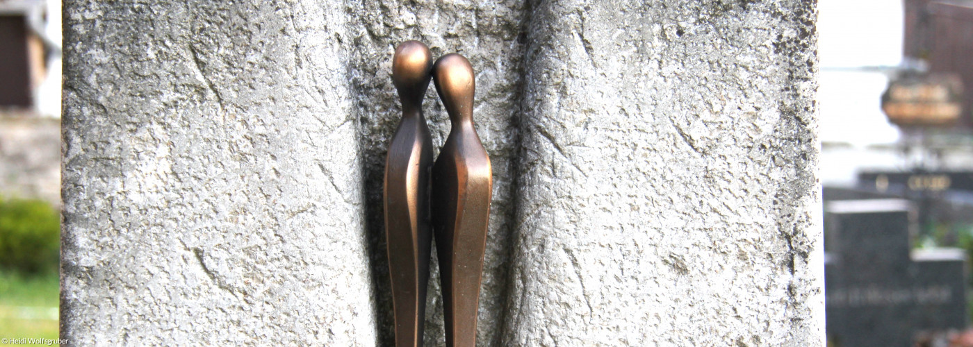 Trauer - Grabstein Uffenheimer Friedhof mit zwei Bronzefiguren, die sich trostvoll begegnen
