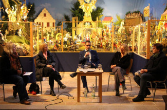 4 Personen sitzen als Talkrunde vor der Fränkischen Weihnachtskrippe im Museum Kirche in Franken