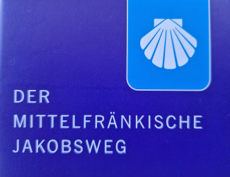 blaues Wegzeichen mit Jakobsmuschel