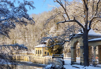 Schneebedeckte Bäume, Pavillon und Fluss im Sonnenschein 