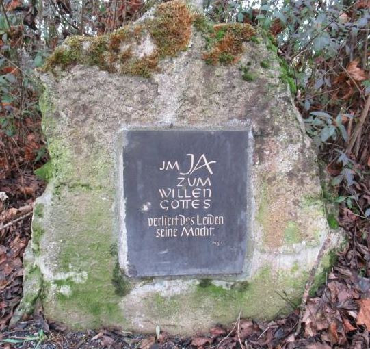 Grabstein mit Inschrift "Im Ja zum Willen Gottes verliert das Leiden seine Macht"