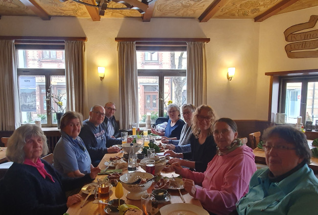 Menschen an langem Tisch beim Weißwurstessen