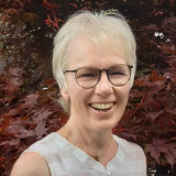 Frau mit weißen Haaren und Brille