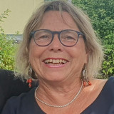 Frau mit blauer Brille und blonden Haaren
