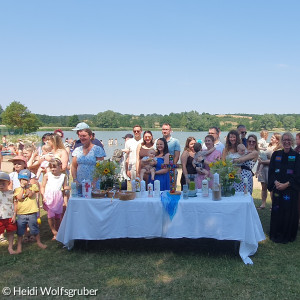 Menschen hinter dem Altar am See