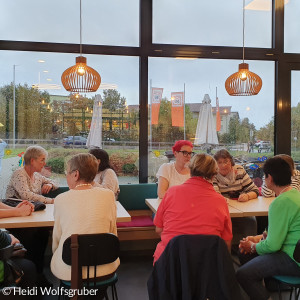 Menschen im Cafe um einen Tisch