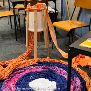 Dieser Teppich in Orange, Pink und Blau ist mit Hilfe einer Riesenstrickliesl unter dem Namen "Projekt Paradiese" entstanden.